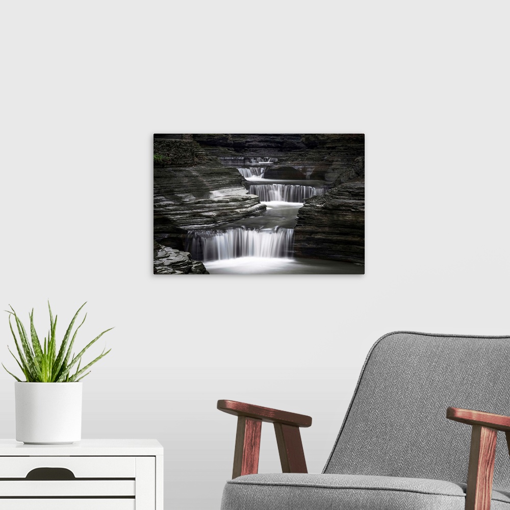A modern room featuring Black and white image of a rushing waterfall in upstate New York.