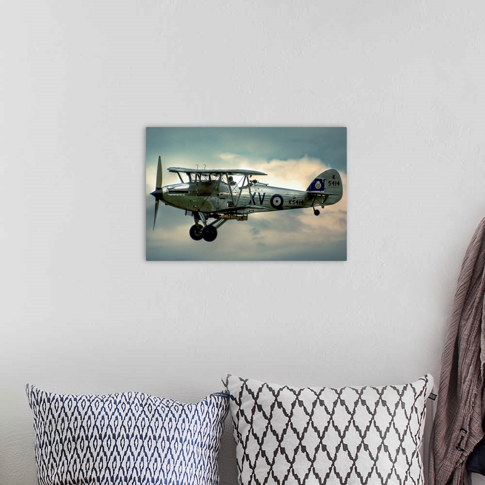 A bohemian room featuring A 1935 Hawker Hind flying on a cloudy day