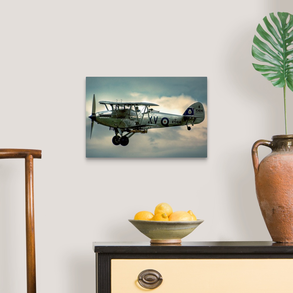 A traditional room featuring A 1935 Hawker Hind flying on a cloudy day