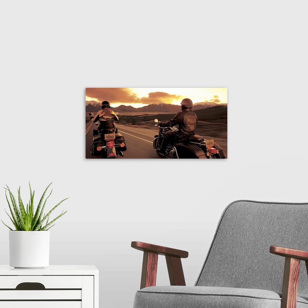 A modern room featuring A couple ride their motorcyles alongside of each other while cruising at sunset