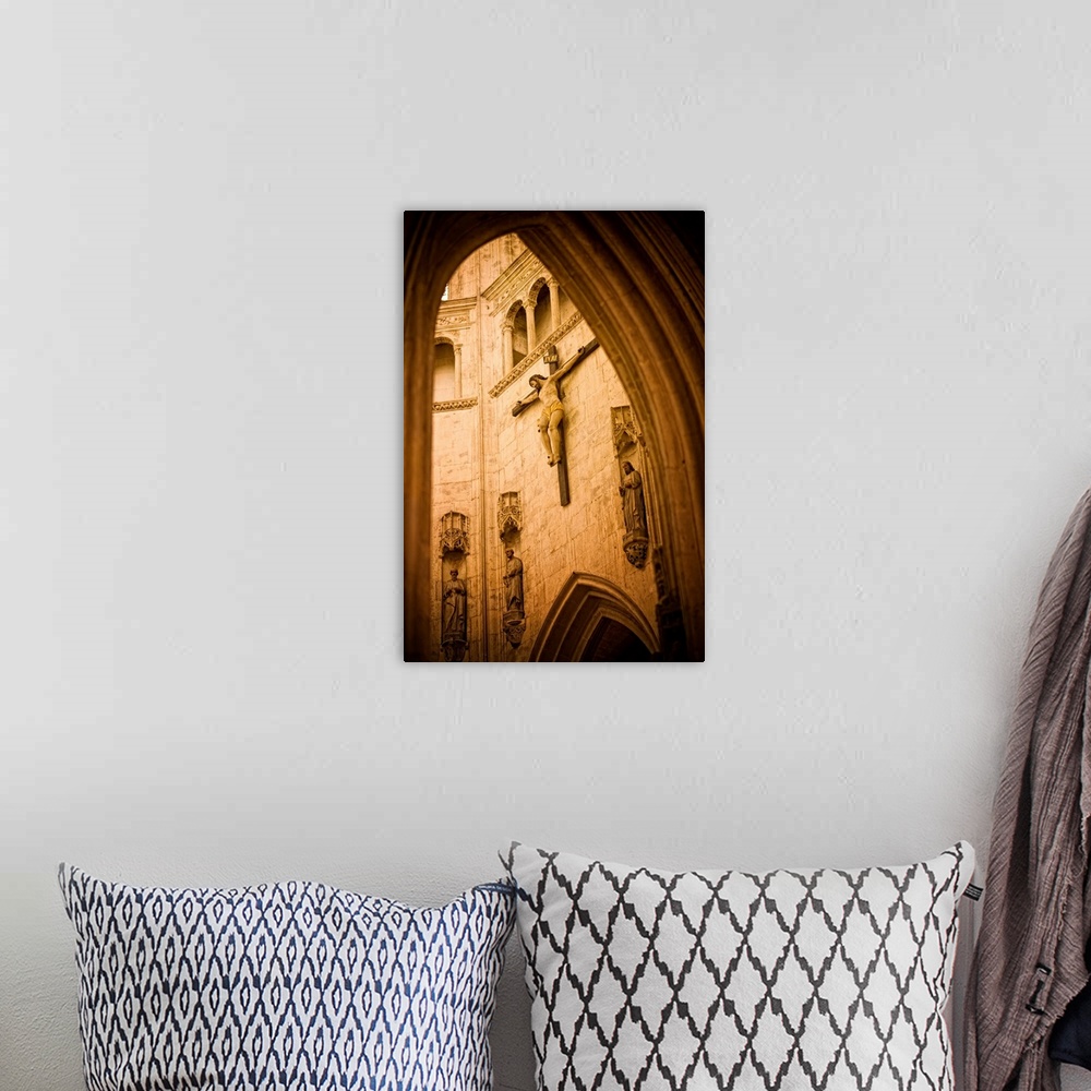 A bohemian room featuring A large crucifix hangs on the inside wall of a beautiful church in France
