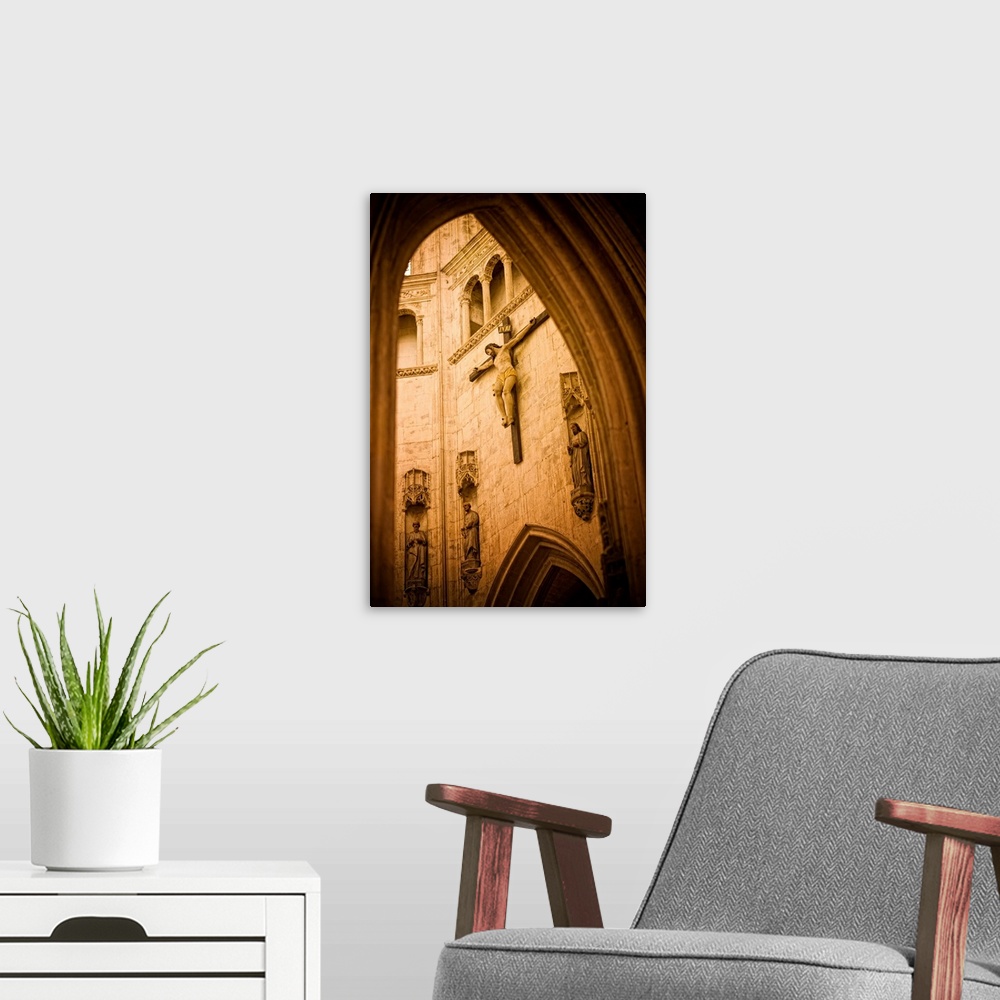 A modern room featuring A large crucifix hangs on the inside wall of a beautiful church in France