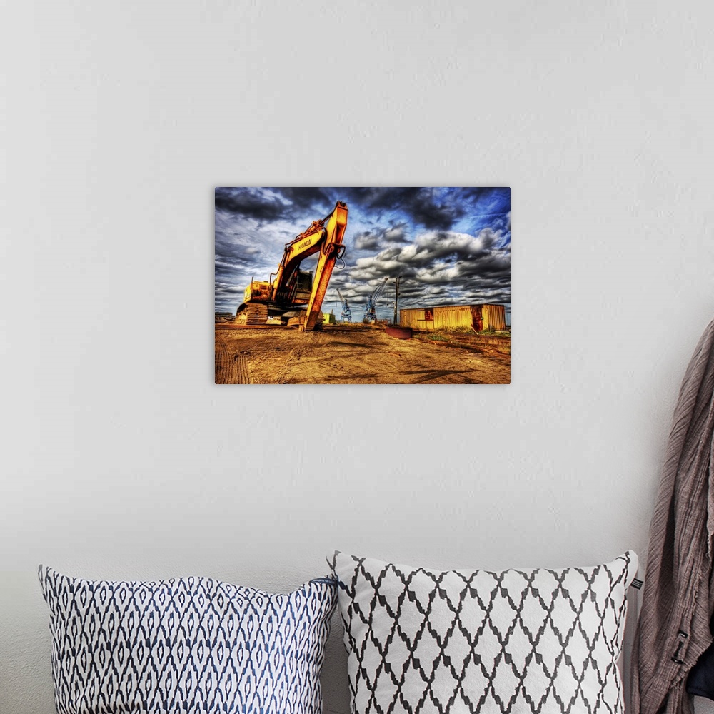 A bohemian room featuring A large yellow digger with caterpillar tracks on a building site with cranes in the distance and ...
