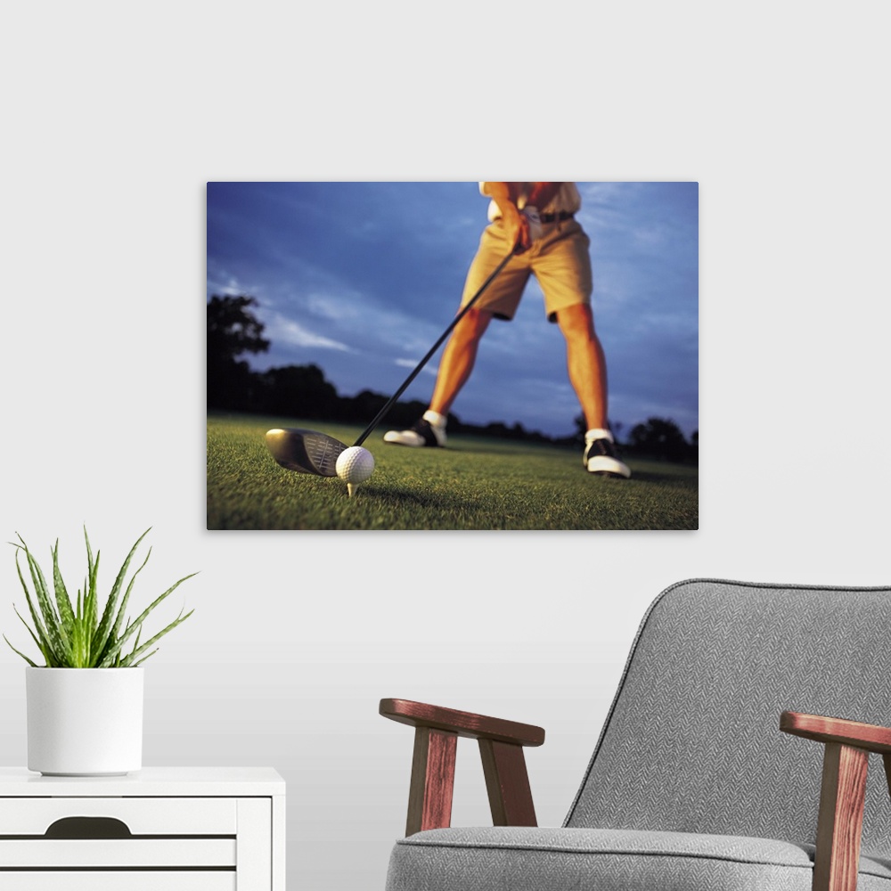 A modern room featuring A low angle shot of a golfer preparing to tee off at a golf course