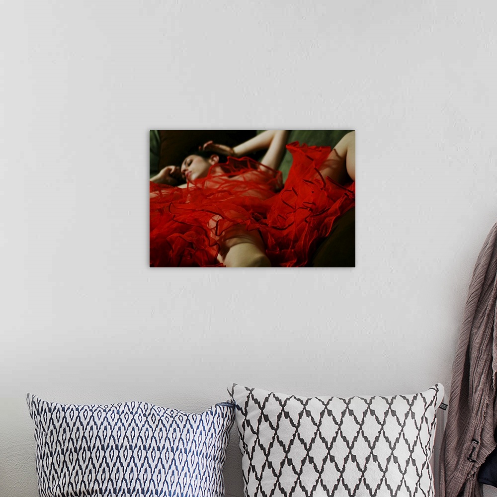 A bohemian room featuring A naked woman lying under a red piece of material