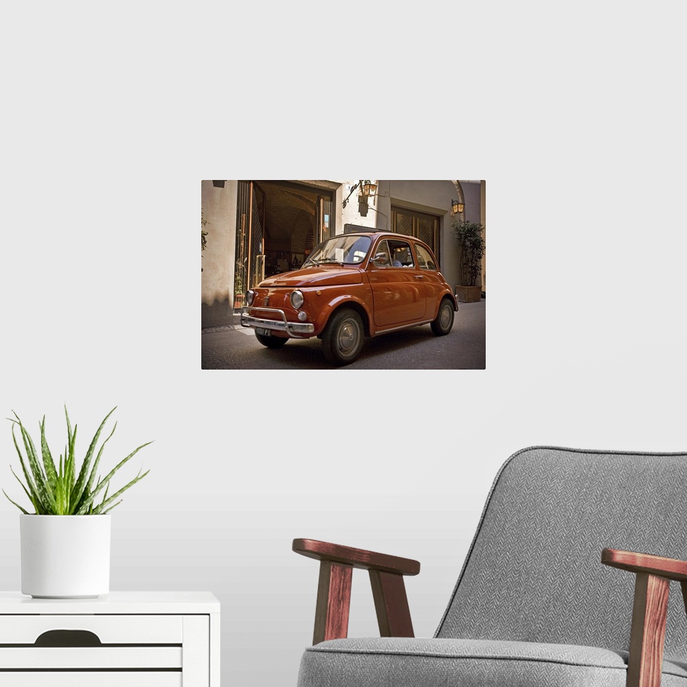 A modern room featuring A small red car drives through the narrow streets in the downtown area of an Italian city.