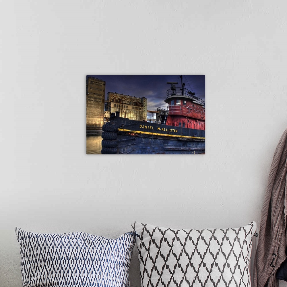 A bohemian room featuring An old tug boat near to industrial buildings