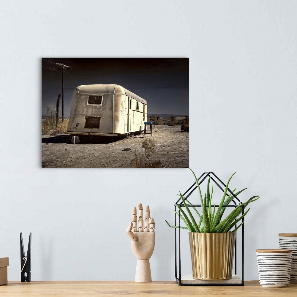 A bohemian room featuring An old white caravan left to rot in the desert