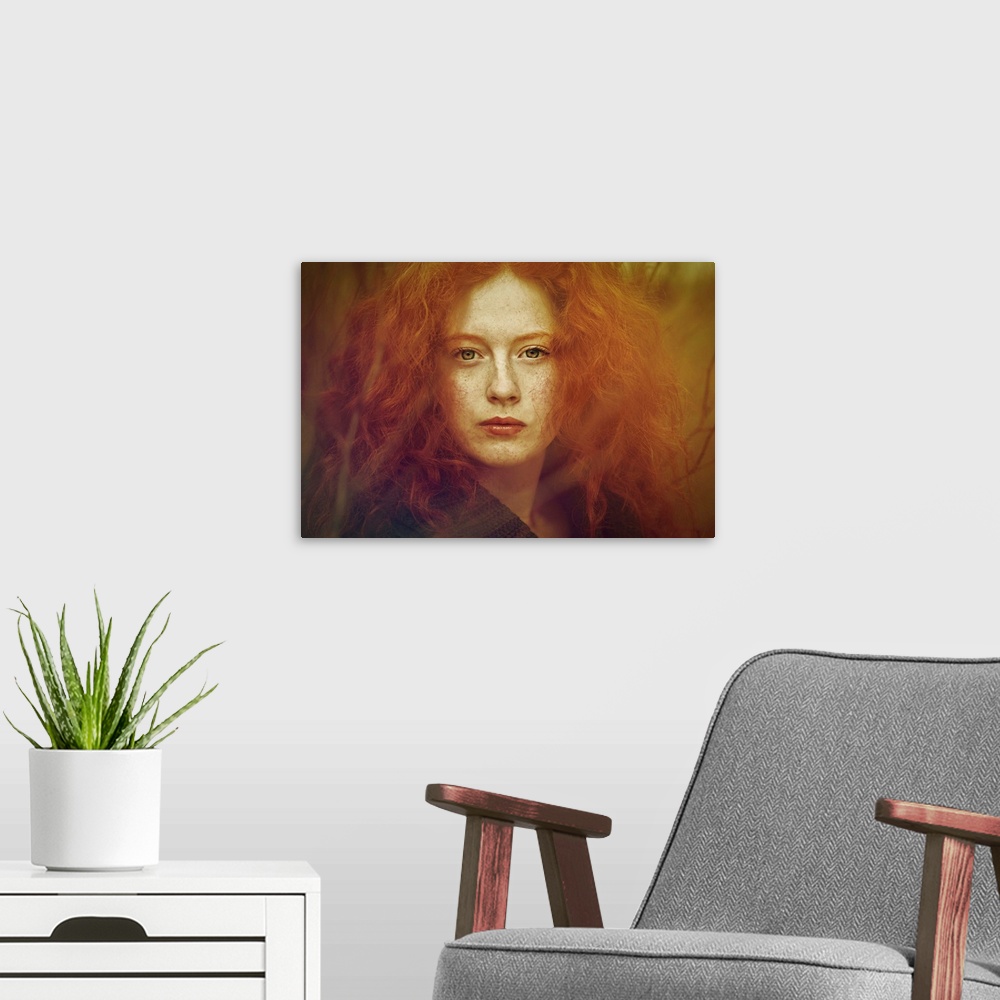 A modern room featuring Close-up portrait of female youth withfreckles, red curly hair and piercing green eyes.