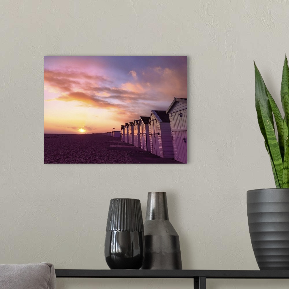 A modern room featuring The sun setting over a Sussex beach with a purple sky.