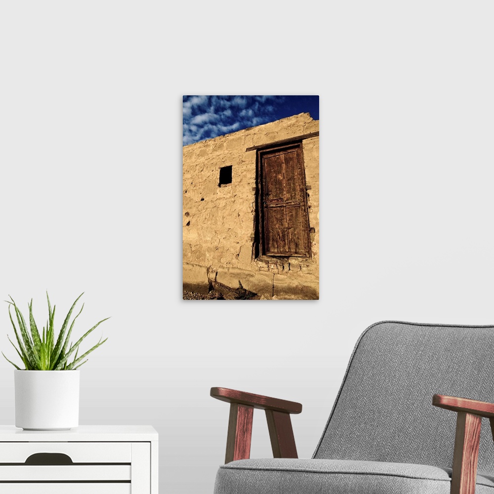 A modern room featuring Brown wooden door with blue sky and clouds, Karnak, Egypt