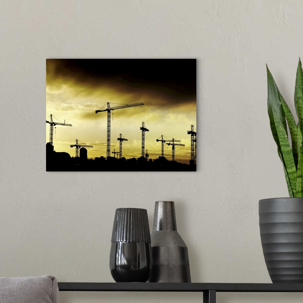 A modern room featuring Building cranes set against a stormy yellow sky