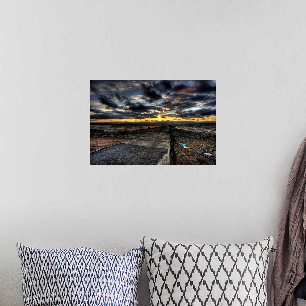 A bohemian room featuring Cloudy evening sunset over an estuary with dramatic stormy clouds looking out over a causeway wit...