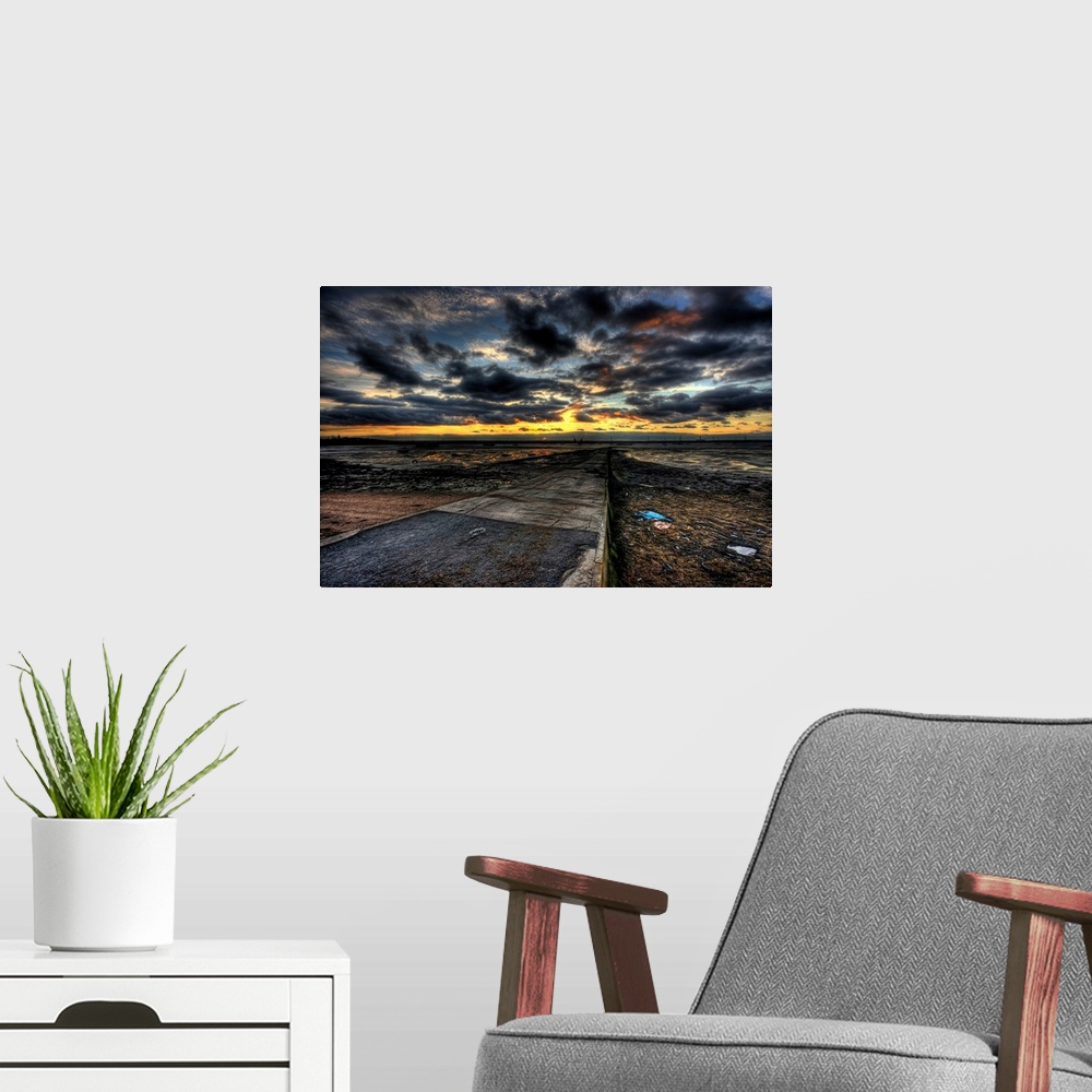 A modern room featuring Cloudy evening sunset over an estuary with dramatic stormy clouds looking out over a causeway wit...