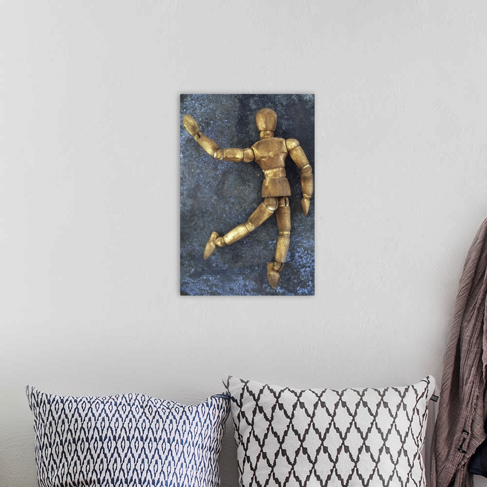 A bohemian room featuring Dark stained wooden mannequin lying on tarnished metal sheet as if running skipping dancing or wa...