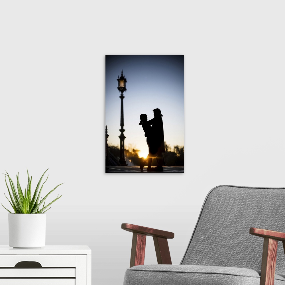 A modern room featuring Young couple embracing at sunset, Plaza de Espana, Seville, Spain.