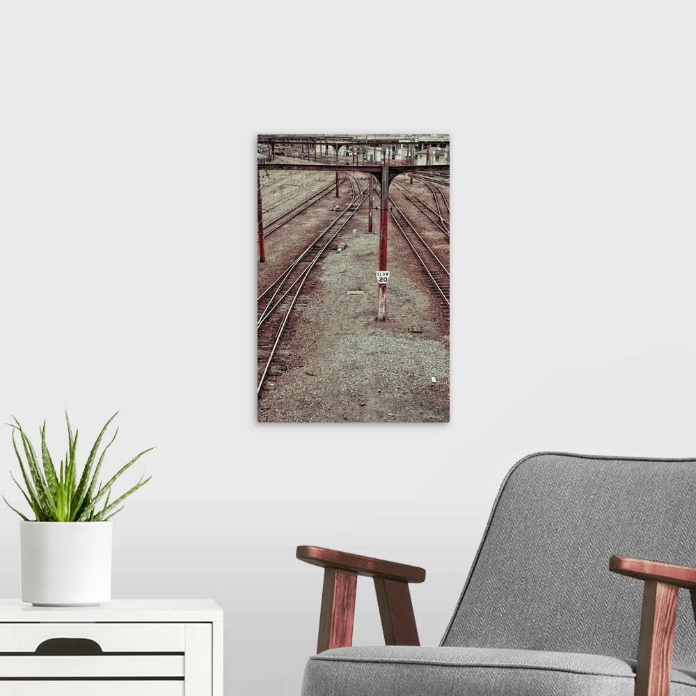 A modern room featuring train tracks leading into a city station