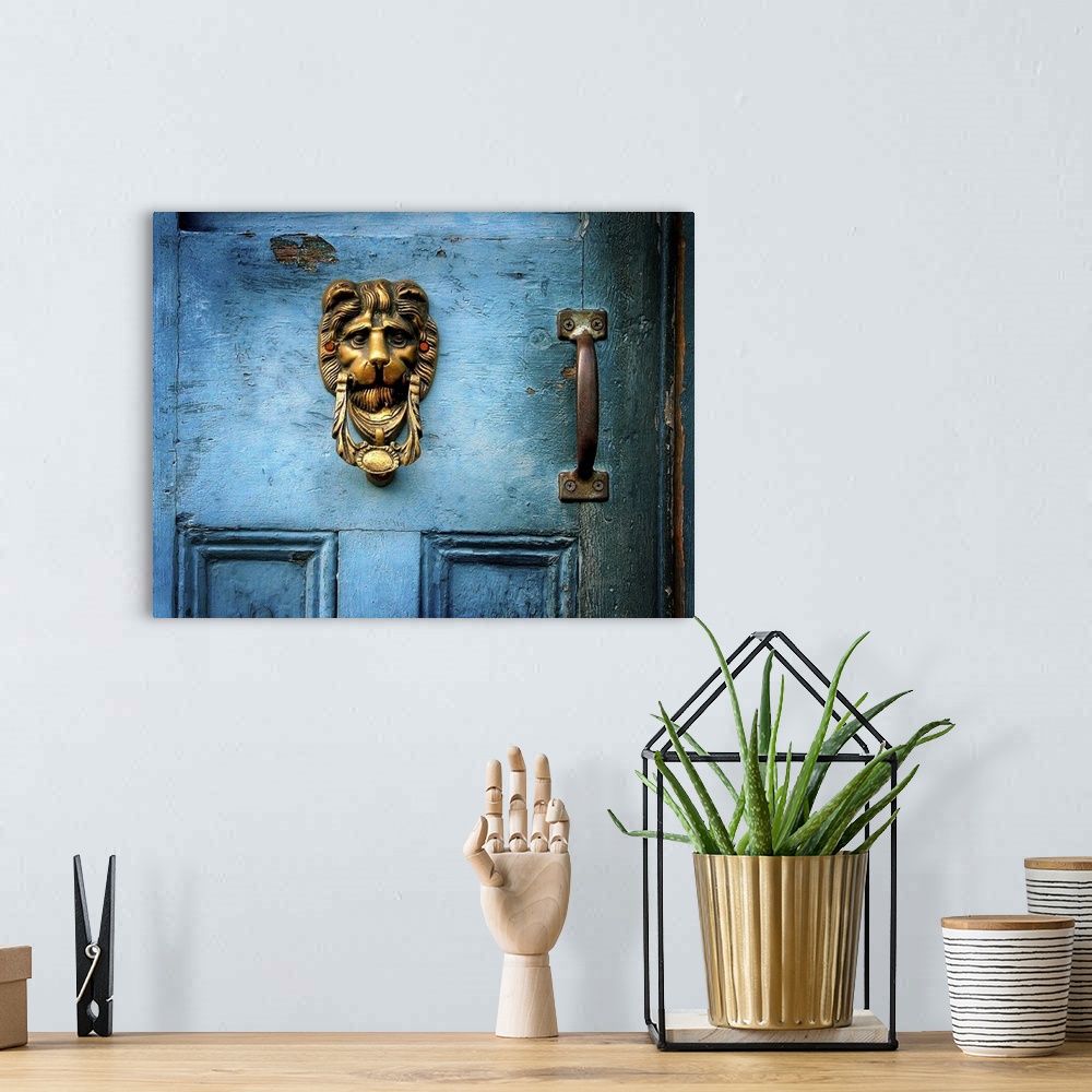 A bohemian room featuring A brass door knocker on a blue door in the shape of a lions head