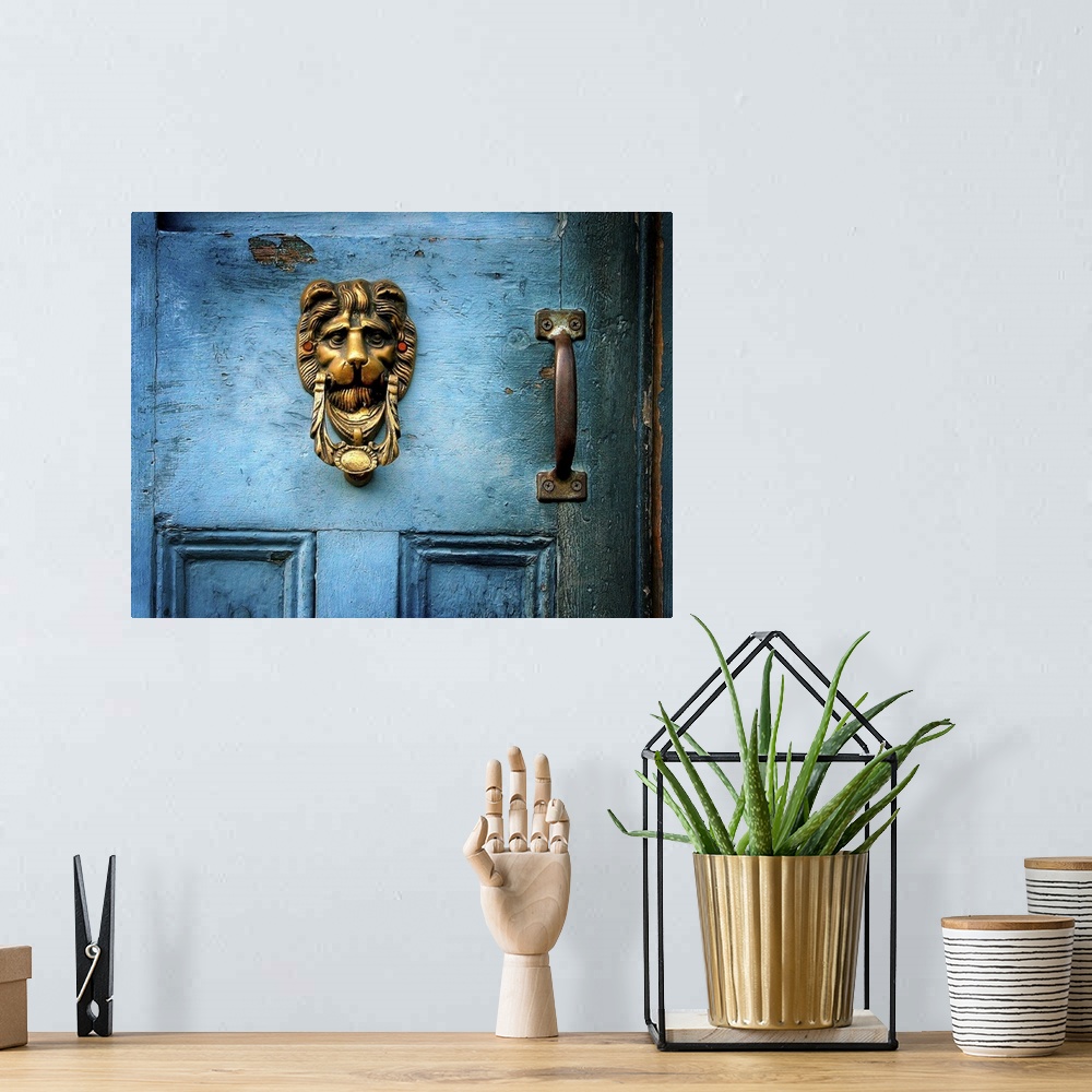 A bohemian room featuring A brass door knocker on a blue door in the shape of a lions head