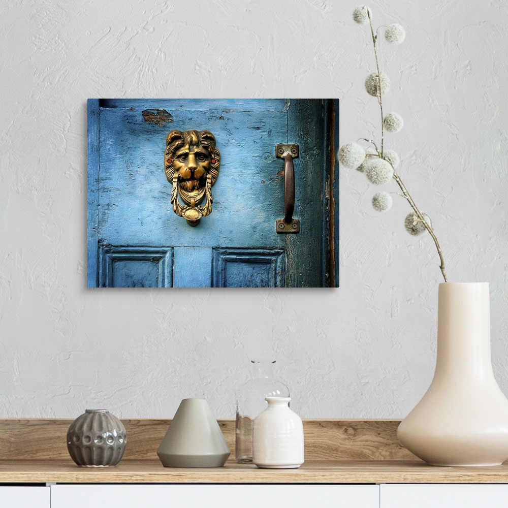 A farmhouse room featuring A brass door knocker on a blue door in the shape of a lions head