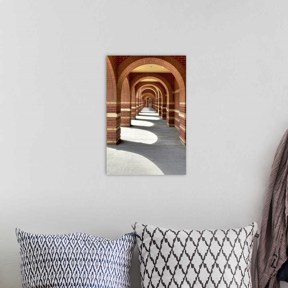 A bohemian room featuring Looking along a line of brick archways with sunlight and shade