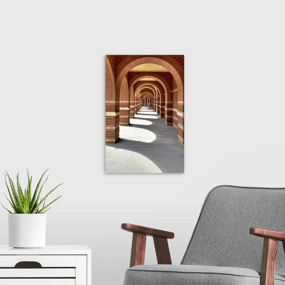 A modern room featuring Looking along a line of brick archways with sunlight and shade