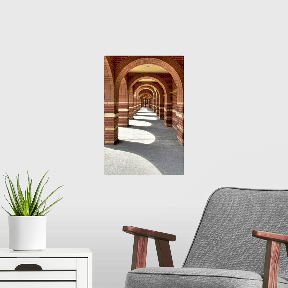 A modern room featuring Looking along a line of brick archways with sunlight and shade