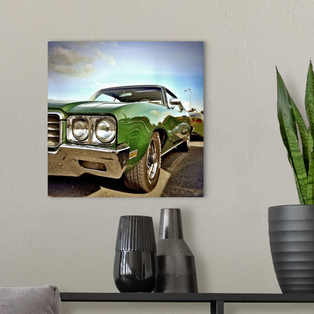 A modern room featuring Green classic USA car form the 1970's with chrome fenders.