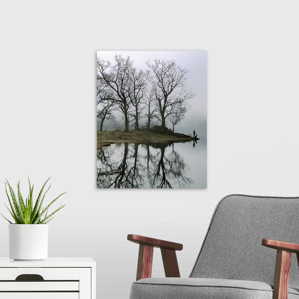 A modern room featuring A figure with a dog standing beside a lake with trees