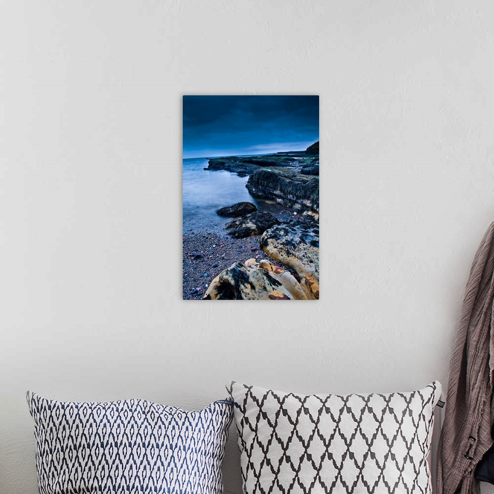 A bohemian room featuring A rocky beach at dusk with storm clouds overhead