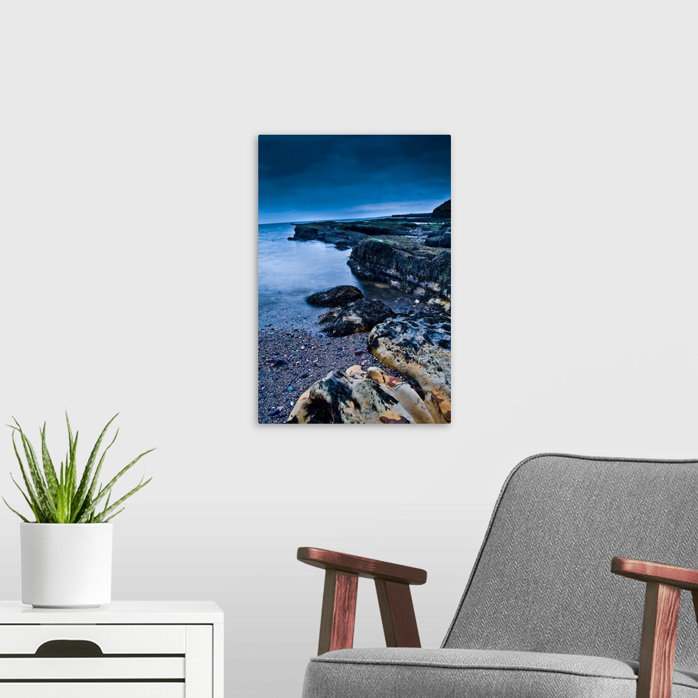 A modern room featuring A rocky beach at dusk with storm clouds overhead