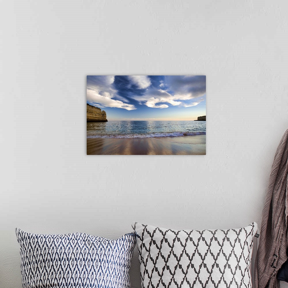 A bohemian room featuring A beautiful picture taken while standing on a beach and looking out at the vast ocean. Cliffs lin...