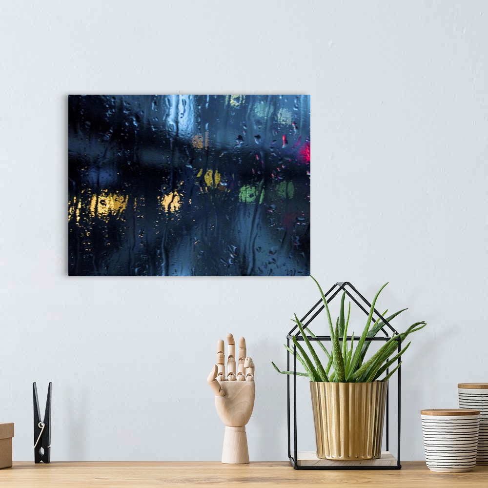 A bohemian room featuring A rain strreaked window with blurred city lights.