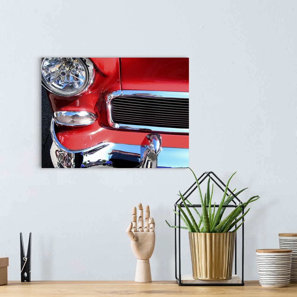 A bohemian room featuring The front of a red car with shiny chrome bumper and grill