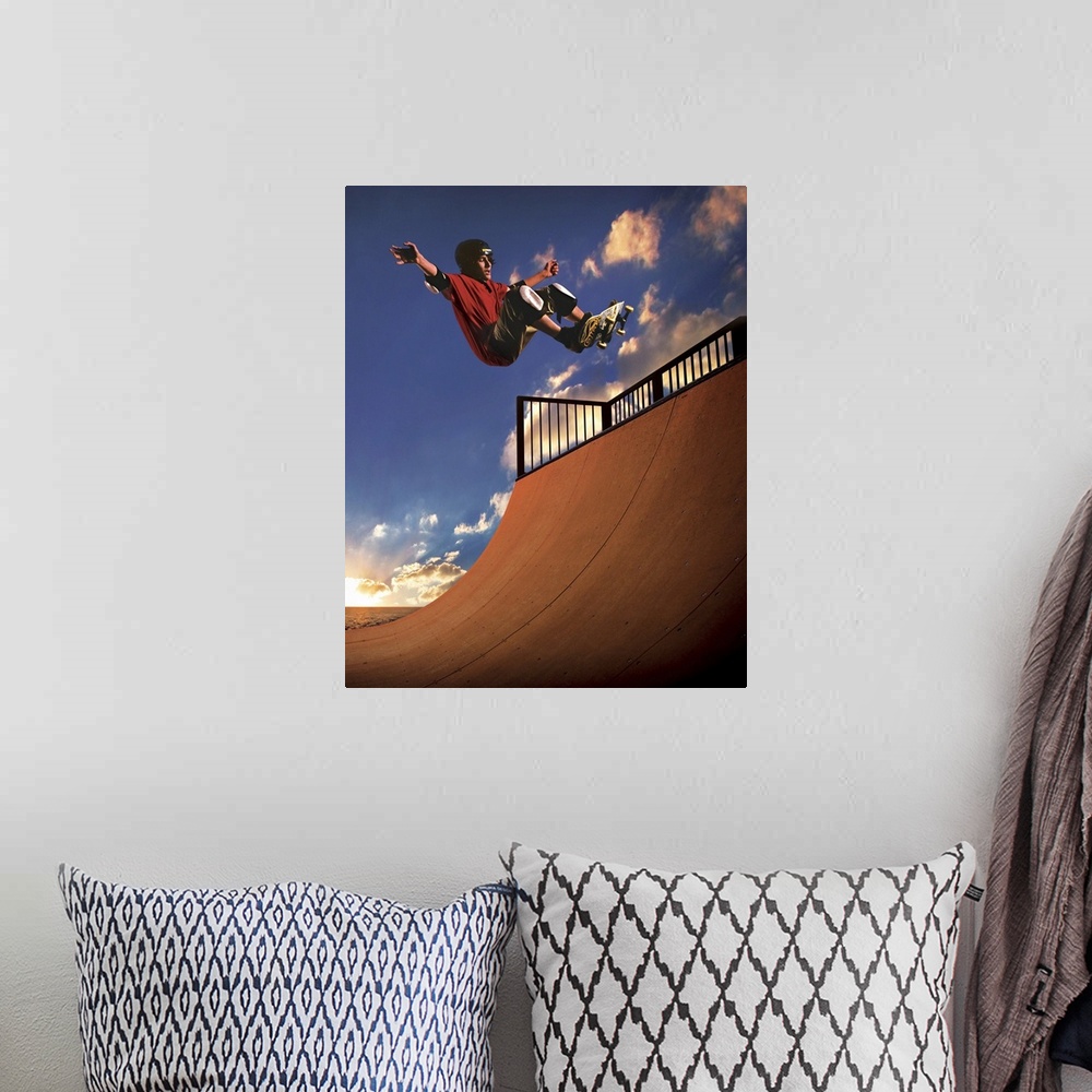 A bohemian room featuring A young boy gets air on his skateboard while skating on a mini ramp at sunset