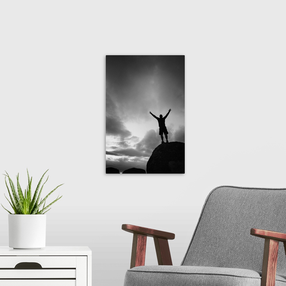 A modern room featuring Silhouette man arms raised into the New Mexico sky in black and