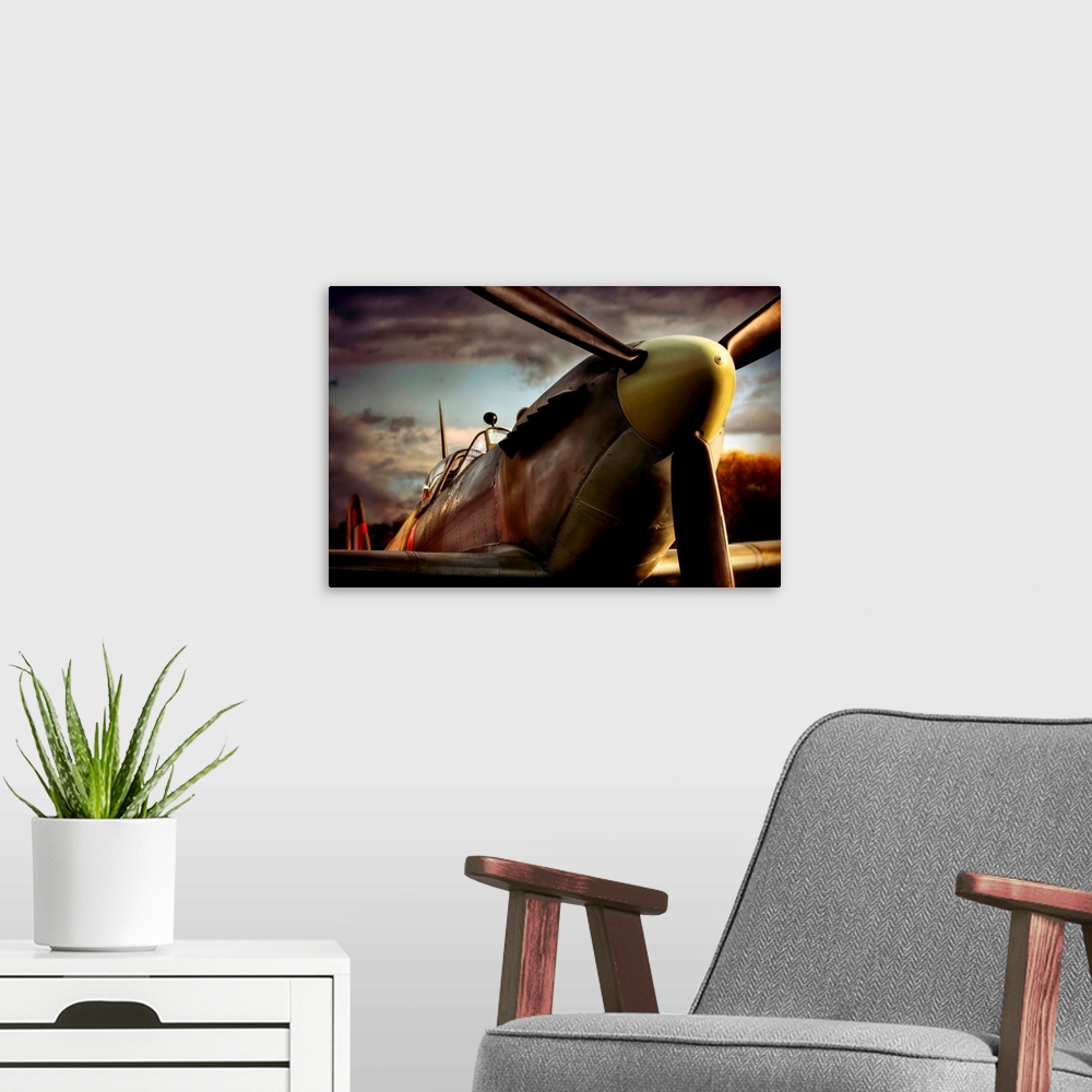 A modern room featuring Close up photograph of British Spitfire with dark cloudy sky in the background.  The plane is a s...
