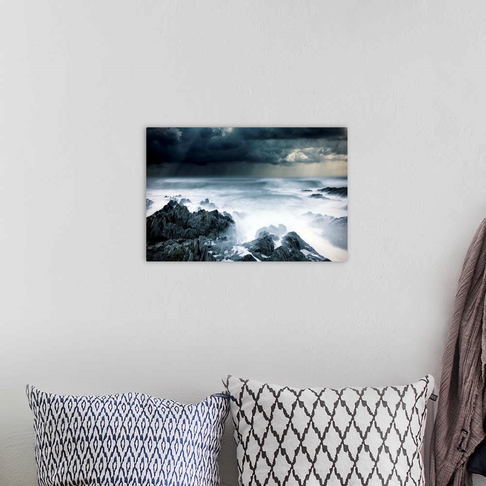 A bohemian room featuring Stormy seascape with rough surf and dark clouds and rocks
