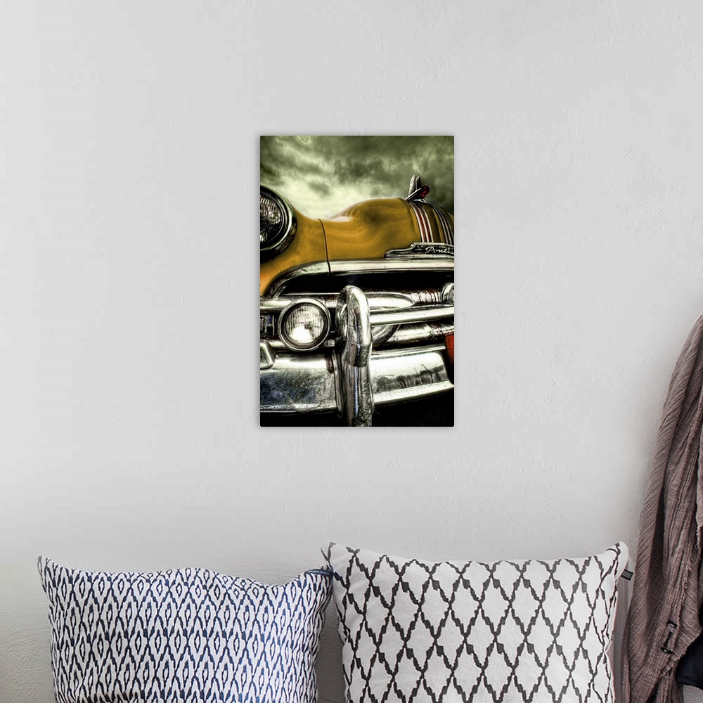 A bohemian room featuring The chrome bumper and yellow bonnet of a classic American car