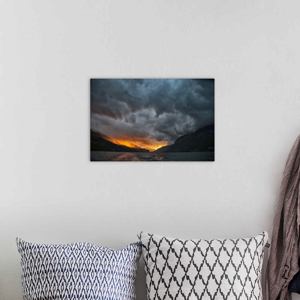 A bohemian room featuring Glowing sunrise/sunset with stormy sky over mountains