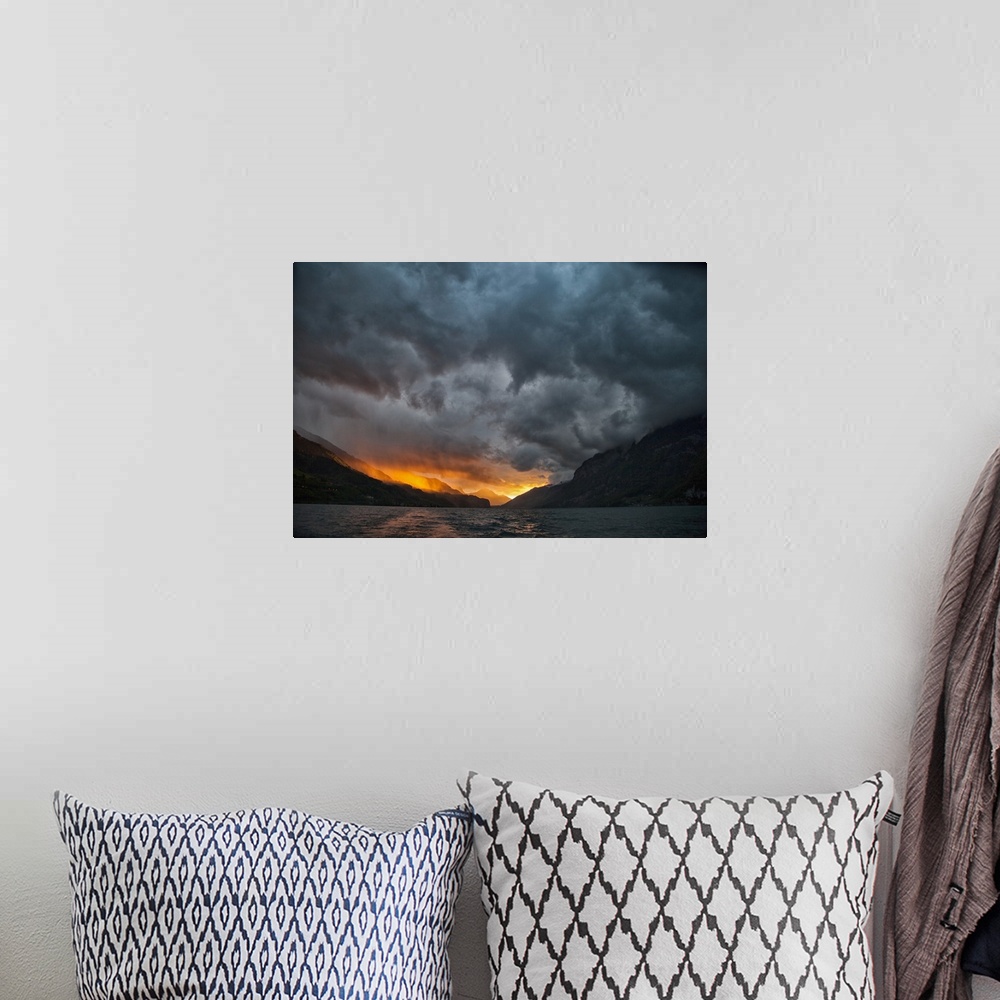A bohemian room featuring Glowing sunrise/sunset with stormy sky over mountains