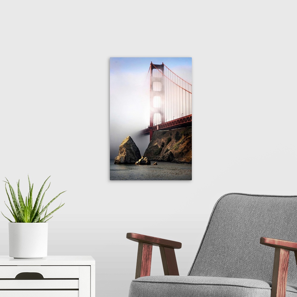 A modern room featuring The Golden Gate bridge shrouded in mist at sunrise