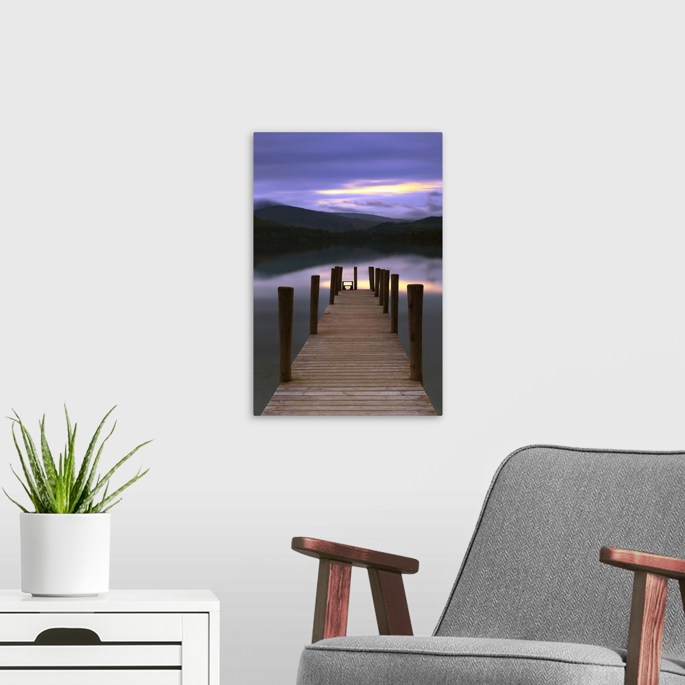 A modern room featuring Jetty at twilight in the Lake District with calm water under a sunset
