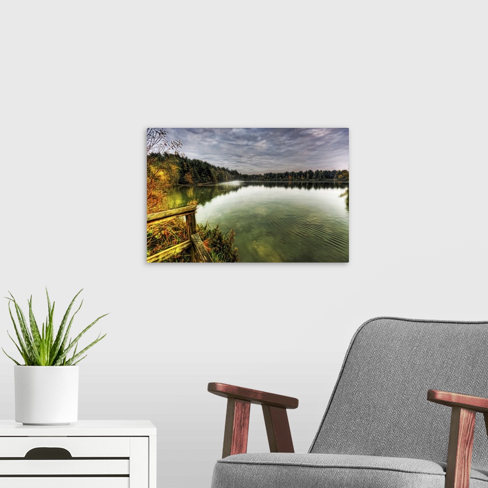 A modern room featuring View from a jetty across a misty foggy smooth boating lake with stormy dramatic skies and surroou...
