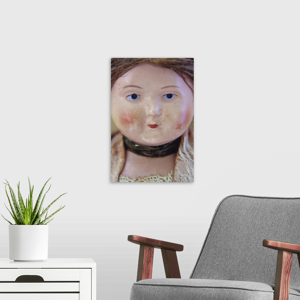 A modern room featuring Face of vintage woman doll with tight bun and glum face and wearing lacy clothes and neckband