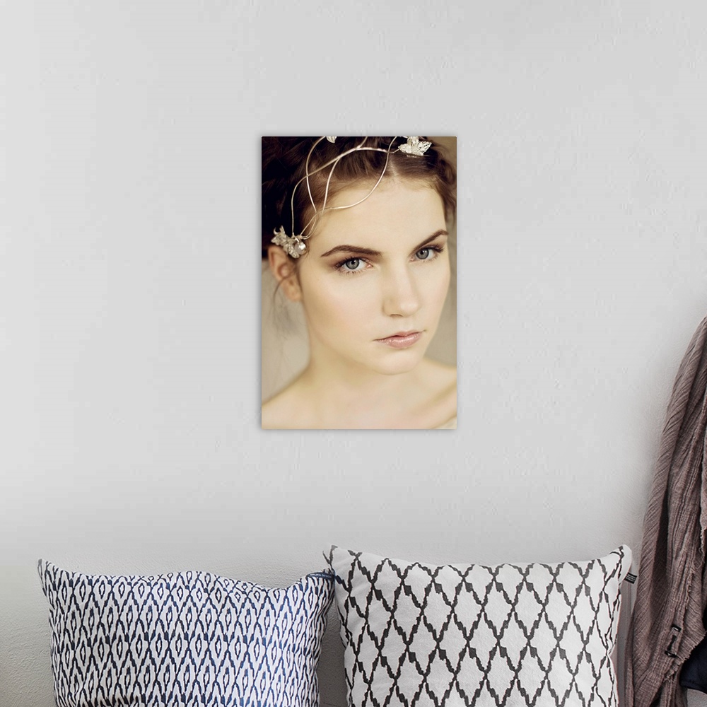 A bohemian room featuring Close portrait of young woman with silver headpiece and braided hair looking into the camera