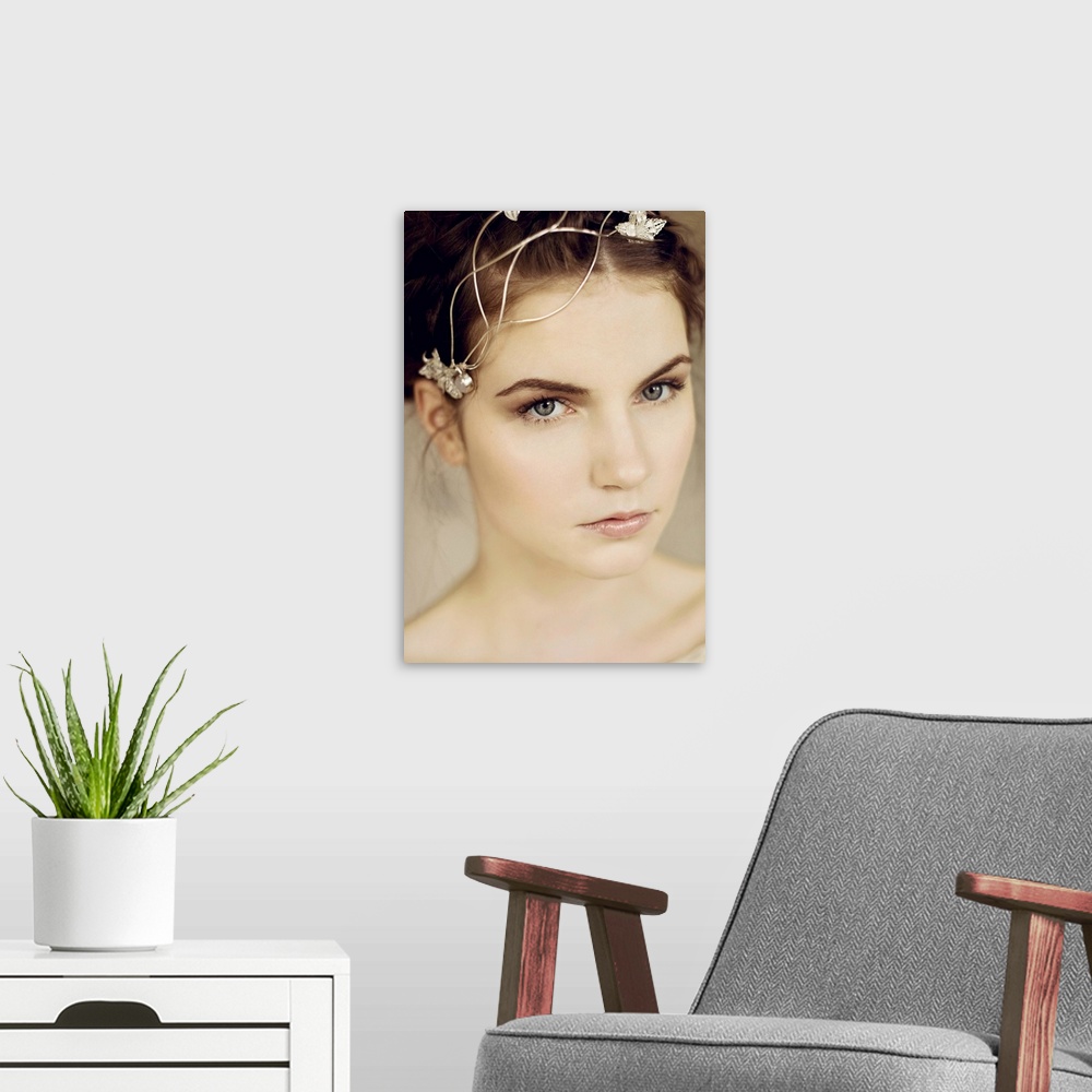 A modern room featuring Close portrait of young woman with silver headpiece and braided hair looking into the camera