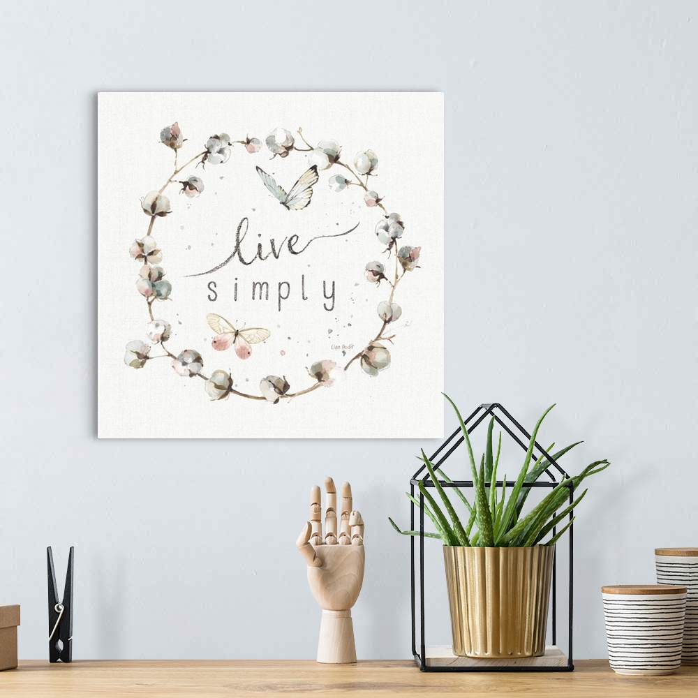 A bohemian room featuring Decorative artwork of a cotton wreath with the words, live simply, in the center.