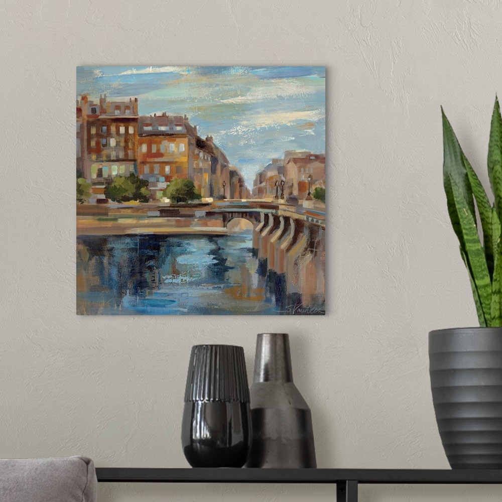 A modern room featuring This contemporary artwork is a painting of scenery in Paris with a small bridge over water and bu...