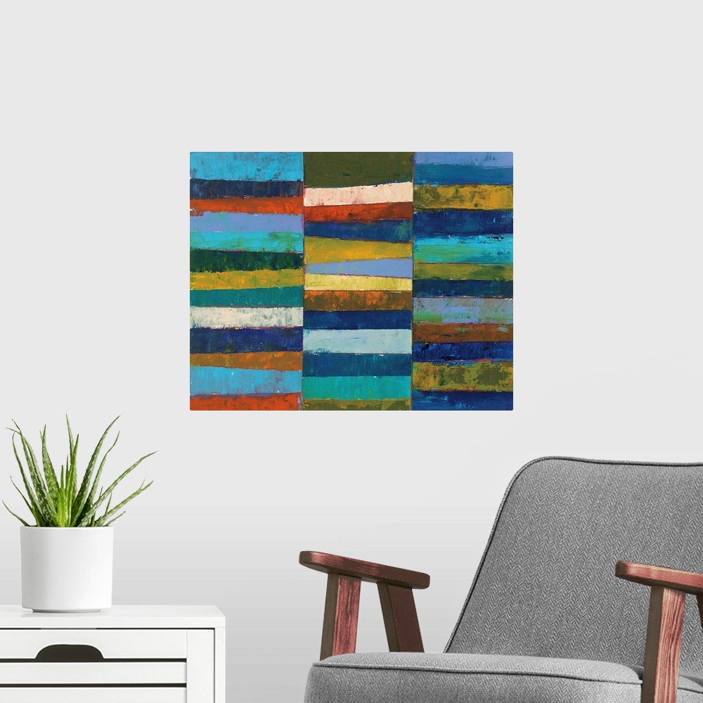 A modern room featuring A bright geometric abstract painting featuring blocks of color stacked in three columns. It has a...